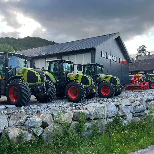 Traktorer fra CLAAS parkert utenfor Bleikvold AS ved et moderne svart bygg.