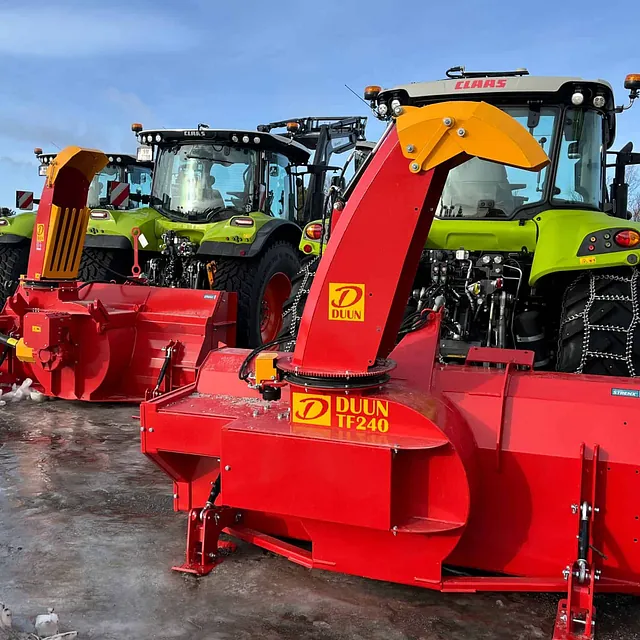 CLAAS-traktorer med Duun snøfresere i rødt og gult, parkert på islagt område.